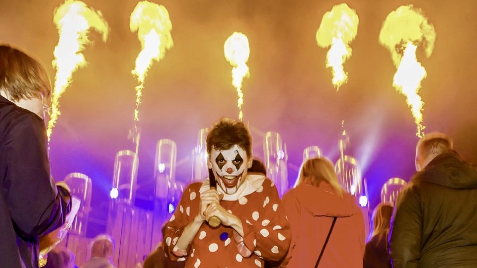 A clown with fire in the air behind from FEAR at Avon Valley Scream Park